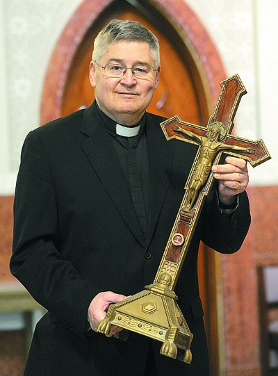 Father Michael Burzynski, pastor of St. John Gilbert in Cheektowaga, holds a relic from the True Cross from the Fourth century. He has donated his relic collection, of over 1,100 pieces, which dates from the First Century through the 20th Century, to the parish. (Dan Cappellazzo/Staff Photographer)